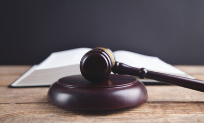 Gavel with book on a wood surface.