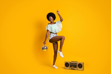 Full length body size photo of black skinned girl boombox wearing shorts top dancing isolated on vibrant yellow color background
