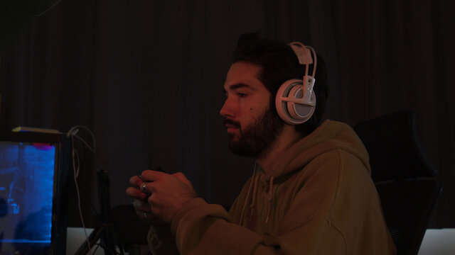 Male gaming with a game pad trying hard and celebrating eratically