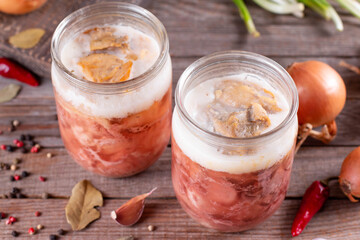 Stew homemade meat in glass jar with spices on wooden background
