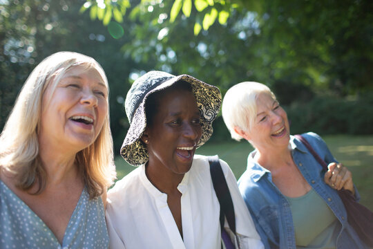 Happy Senior Women Friends Laughing In Sunny Summer Garden