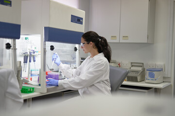 Female scientist with pipette working at fume hood in laboratory