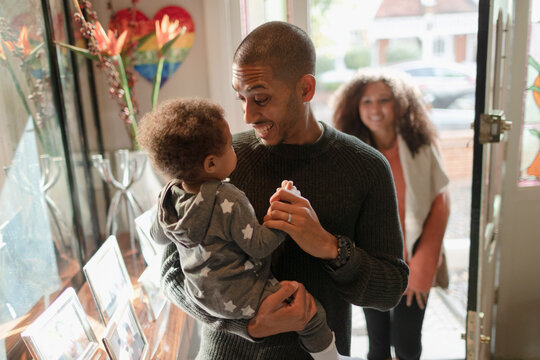 Happy father holding baby daughter at front door