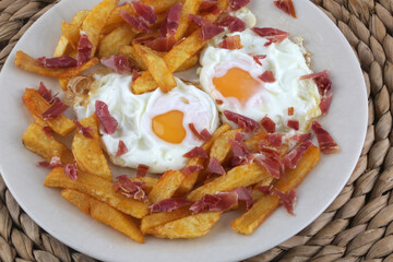 fried eggs wirh potatoes and sliced ham