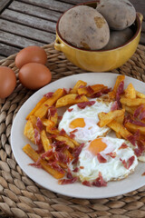 fried eggs wirh potatoes and sliced ham