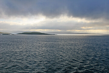 sunset over the sea with shetland isles in the distance
