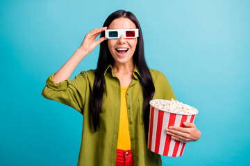 Photo of positive lady hold big paper box popcorn having fun wear 3d glasses green shirt isolated blue color background