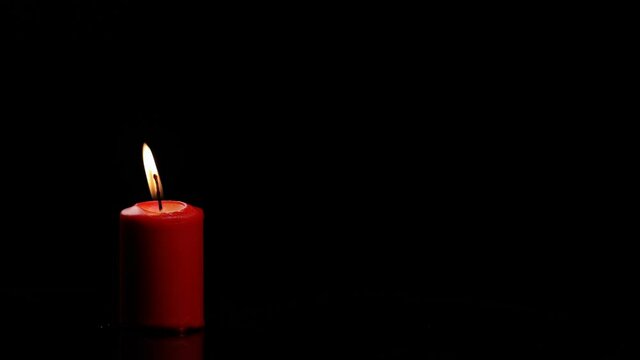 Red candle burns and goes out and gives a beautiful smoke on a black background