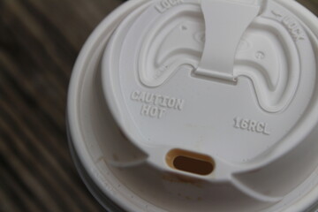 Looking down on a to go coffee drink with coffee stains on the mouth of the lid.