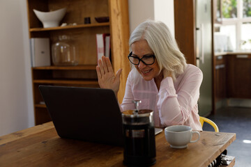 Senior caucasian woman having a video chat on laptop while working from home