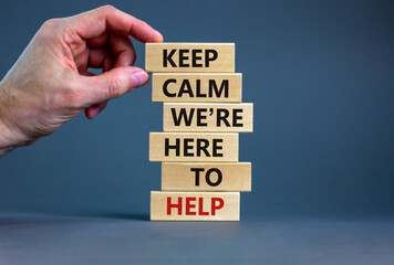 Here to help symbol. Male hand builds stack from blocks with words 'keep calm we are here to help'. Beautiful grey background. Copy space. Business and here to help concept.