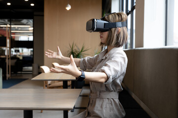 Asian businesswoman wearing virtual reality headset in creative office