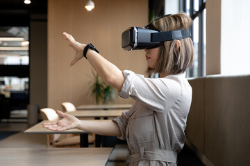 Asian businesswoman wearing virtual reality headset in creative office