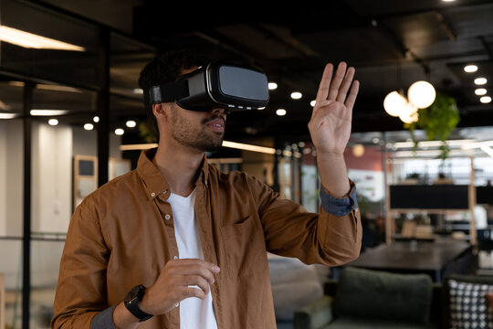 Mixed race businessman wearing virtual reality headset in creative office