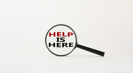 Here to help symbol. Magnifying glass with text 'help is here' on beautiful white background. Business and help is here concept, copy space.
