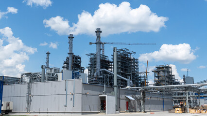 Refinery process area of petrochemical plant on classic blue sky with clouds background. Oil refining concept.