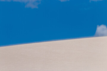Sand dune against blue sky.