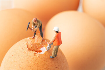 Macrophotographie: figurines cassent un oeuf