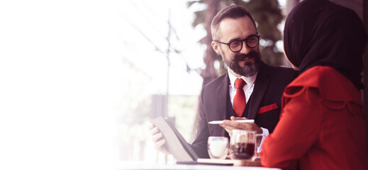 Caucasian businessman Negotiating business with a Muslim businesswoman