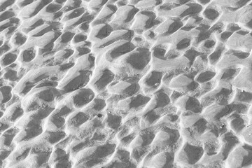Fototapeta na wymiar Irregular pattern in he sand in black and white seen from above