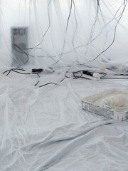 Fototapeta na wymiar Cables Covered In Dust Sheets With Paint Roller In Foreground