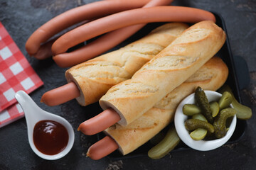 French or czech style hot dogs with sausages in baguette, elevated view on a brown stone background