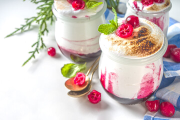 Cranberry layered Dessert breakfast in small jars for Christmas morning. Homemade baked Cranberry meringue dessert, with fresh cranberries and mint, copy space