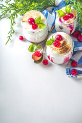 Obraz na płótnie Canvas Cranberry layered Dessert breakfast in small jars for Christmas morning. Homemade baked Cranberry meringue dessert, with fresh cranberries and mint, copy space