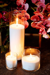 Lighted bulk candles made of loose paraffin wax in glass flasks.