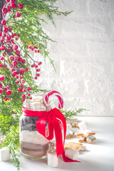 Hot chocolate dry mix in mason jar. Christmas and winter holiday handmade gifts idea. Edible handmade Christmas gift, on white background with Xmas gingerbread cookies and Xmas decorations