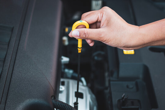 A woman's hand checking engine oil