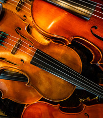 Close-up of a pile of violins on a diagonal.