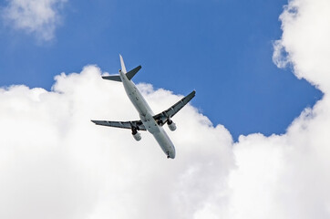 Airplane in the blue sky with clouds