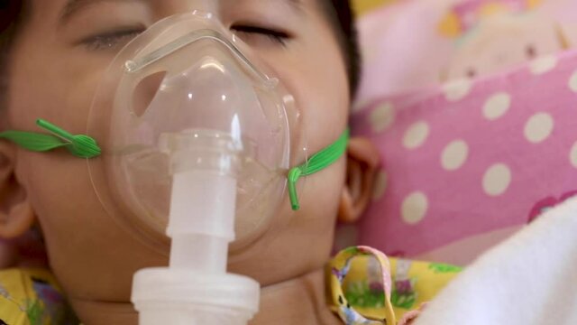 Asian little boy making inhalation with nebulizer at hospital, Nebulization concept