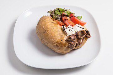 Delicious stuffed sweet potato with cheese, anchoa, tomato and salad