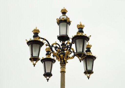 City lightning and illumination. Closeup view of beautiful street lights with baroque and rococo decoration in golden details in Madrid, Spain.   