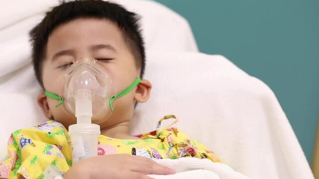 Asian little boy making inhalation with nebulizer at hospital, Nebulization concept