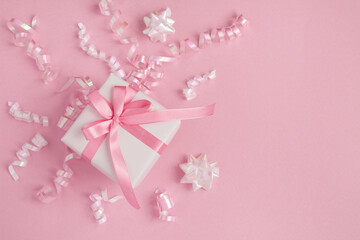 Top view of white gift box and confetti on the pink background with copy space