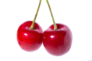 Two organic sweet cherries isolated on a white background.
