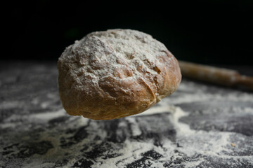 Bread falling or flying on floury black table.Concept of bakery, baking and cooking