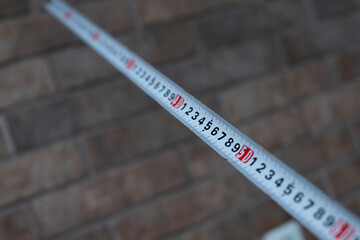 measuring tape on brick wall background