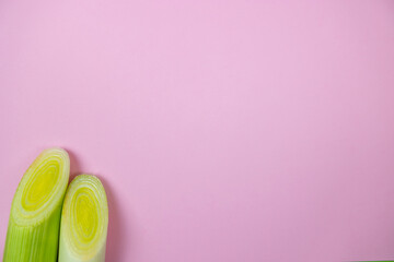 fresh green leeks on the pink background