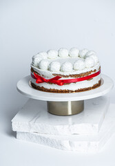 Coconut cake with coconut balls on top, white background