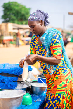 image of colorful african woman, with african local food in a plastic- food  concept