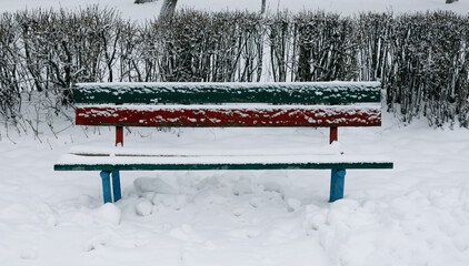 Street bench covered with white snow