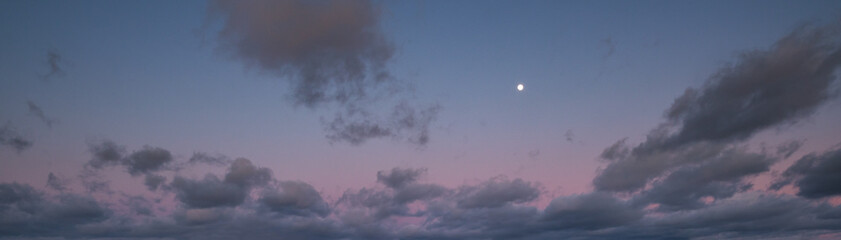 Clouds and full Moon in twilight sky view. Panoramic night sky background.