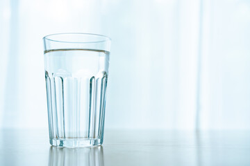 Drinking water in a glass left on the table in office, work life balance concept with copyspace. Modern woking lifestyle and healthcare
