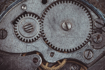 Vintage watch movement close - up. Selective focus on elements, macro photography. Background in steampunk style. Metallic grunge texture. Easy image tinting