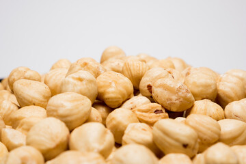 Whole hazelnuts on the white background. Healthy vegetarian snack. Close-up photo. Copy-space for your text.