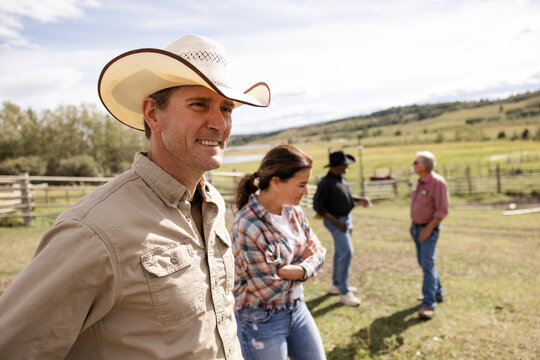 Portrait male rancher in cowboy hat in sunny rural pasture